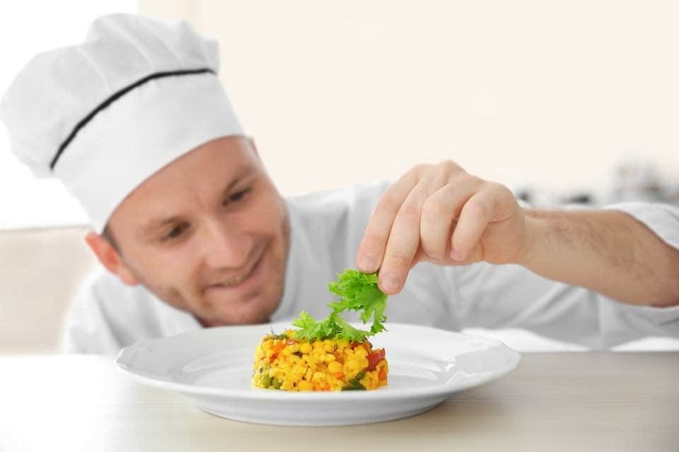 طباخ يضع الخس ويزين به طبق من سلطة الذرة